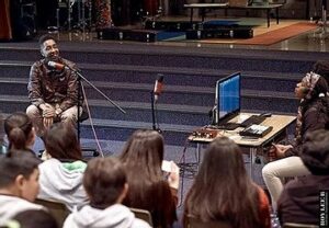 A student interviews hip hop star Oddissee for the podcast in front of an audience.